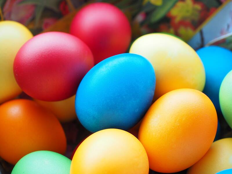 Mehrere bunt gefärbte Ostereier liegen dicht nebeneinander.