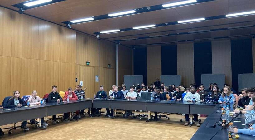 Das Jugend.Forum 2024 fand im Sitzungssaal des Rathauses der Stadt Dorfen statt. Es sitzen viele junge Menschen um einen U-förmigen Tisch und schauen nach vorne.