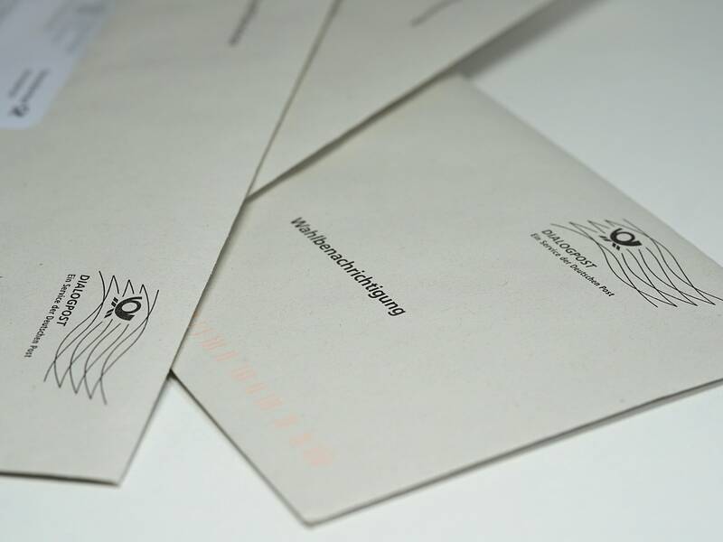 Einige Umschläge mit der Aufschrift "Wahlbenachrichtigung" liegen auf einer Oberfläche.