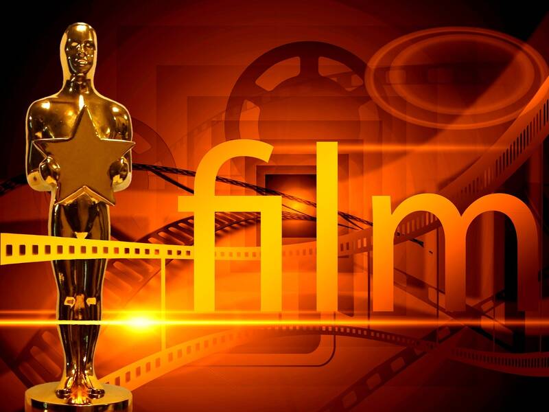 Ein goldener Filmpreis in Form einer Statue mit einem Stern darauf steht vor einem Hintergrund mit Filmrollen und dem Schriftzug "film".
